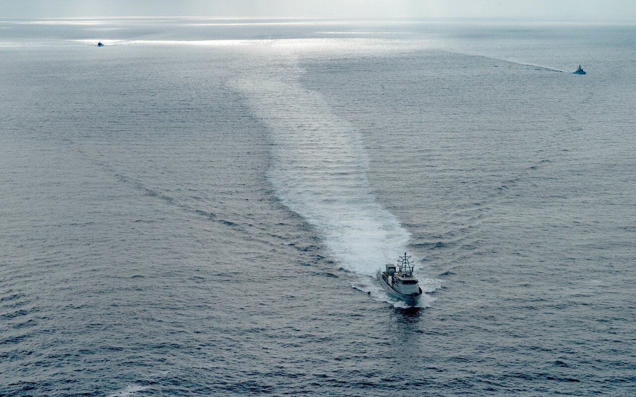 Trois drones de surface manoeuvrent en mer, vus d'avion